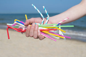 Plastic straws in hand