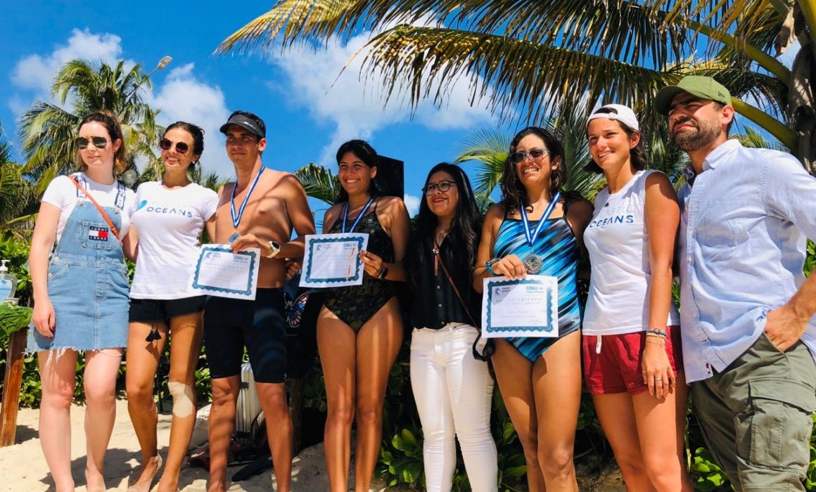 The participants of Swim Against Plastic Riviera Maya posing with their awards.