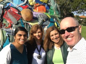 Chile´s Executive Director Mark posing with some people in front of a Plastic sculpture made from waste