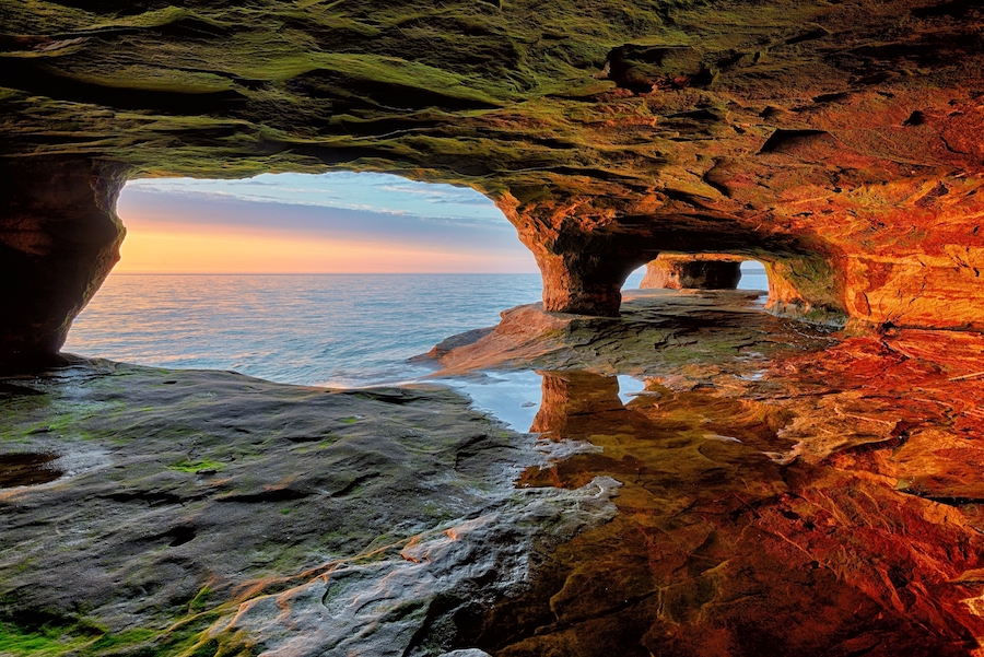 Puesta del sol hermosa de la cueva del mar en el lago Superior, en las rocas nacionales representadas a orillas del lago.