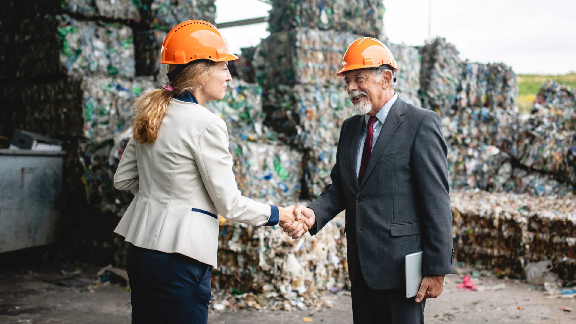 recycling bundles with two people shaking hands